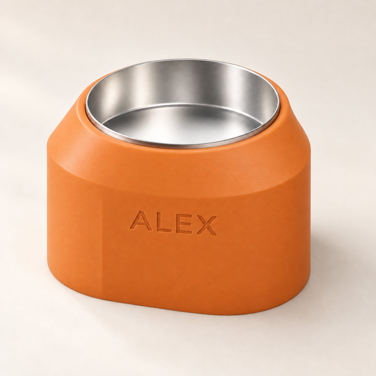 Cove Smooth custom-height dog bowl in Mandarin Orange, with a removable stainless-steel bowl; ALEX is an example name
