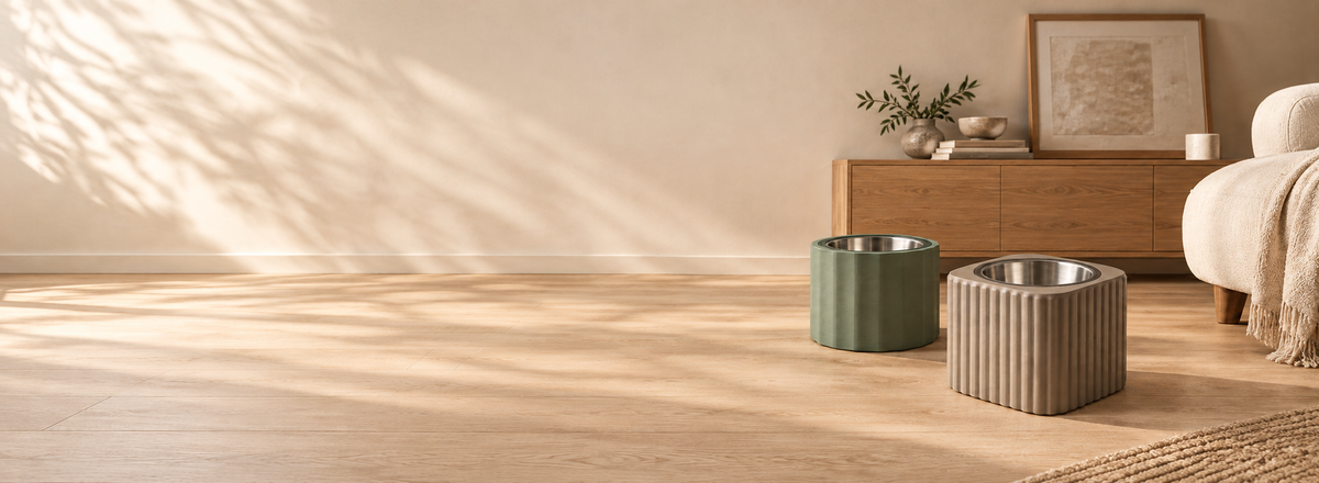 AI-generated design illustration of warm taupe Ridge Base and olive Flute Base dog bowls beside oak and linen furniture.