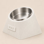 Contour Tilt custom height dog bowl in Ivory White, with a tilted stainless steel bowl, fine vertical grooves and MAX example nameplate.